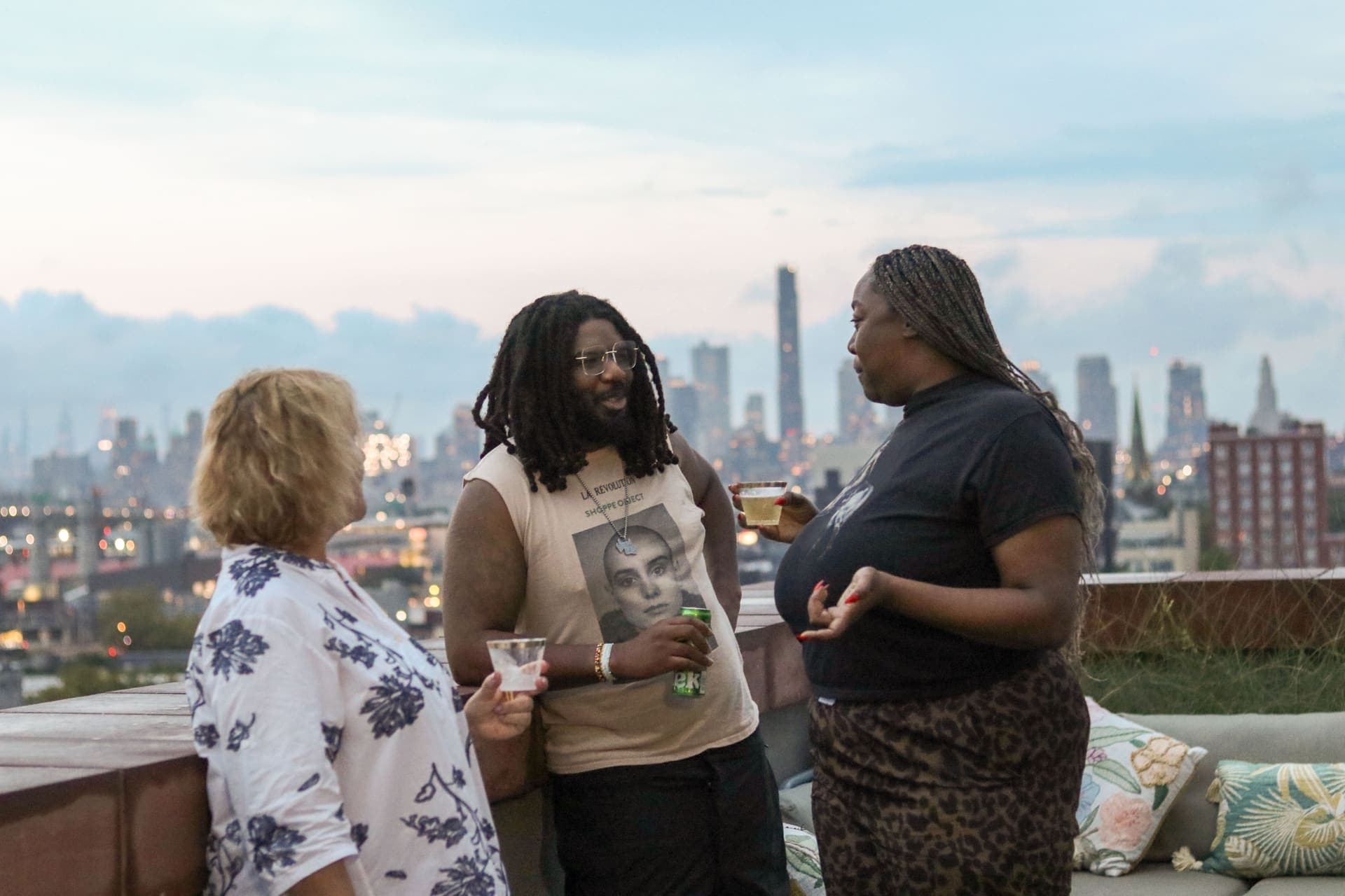 Residents in conversation with the Manhattan skyline behind them from the rooftop terrace at 875 Fourth Avenue