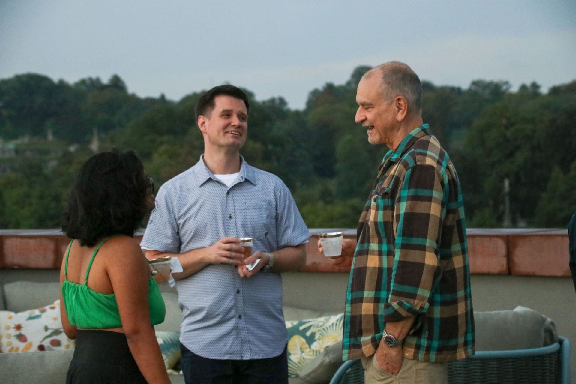 Residents laughing together beside the terrace seating at 875 Fourth Avenue