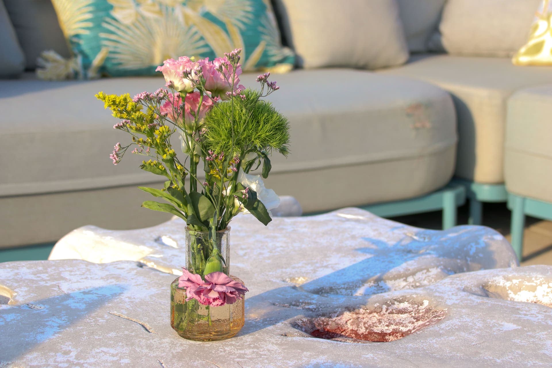 Fresh flowers on a lounge table with terrace seating behind on the rooftop at 875 Fourth Avenue