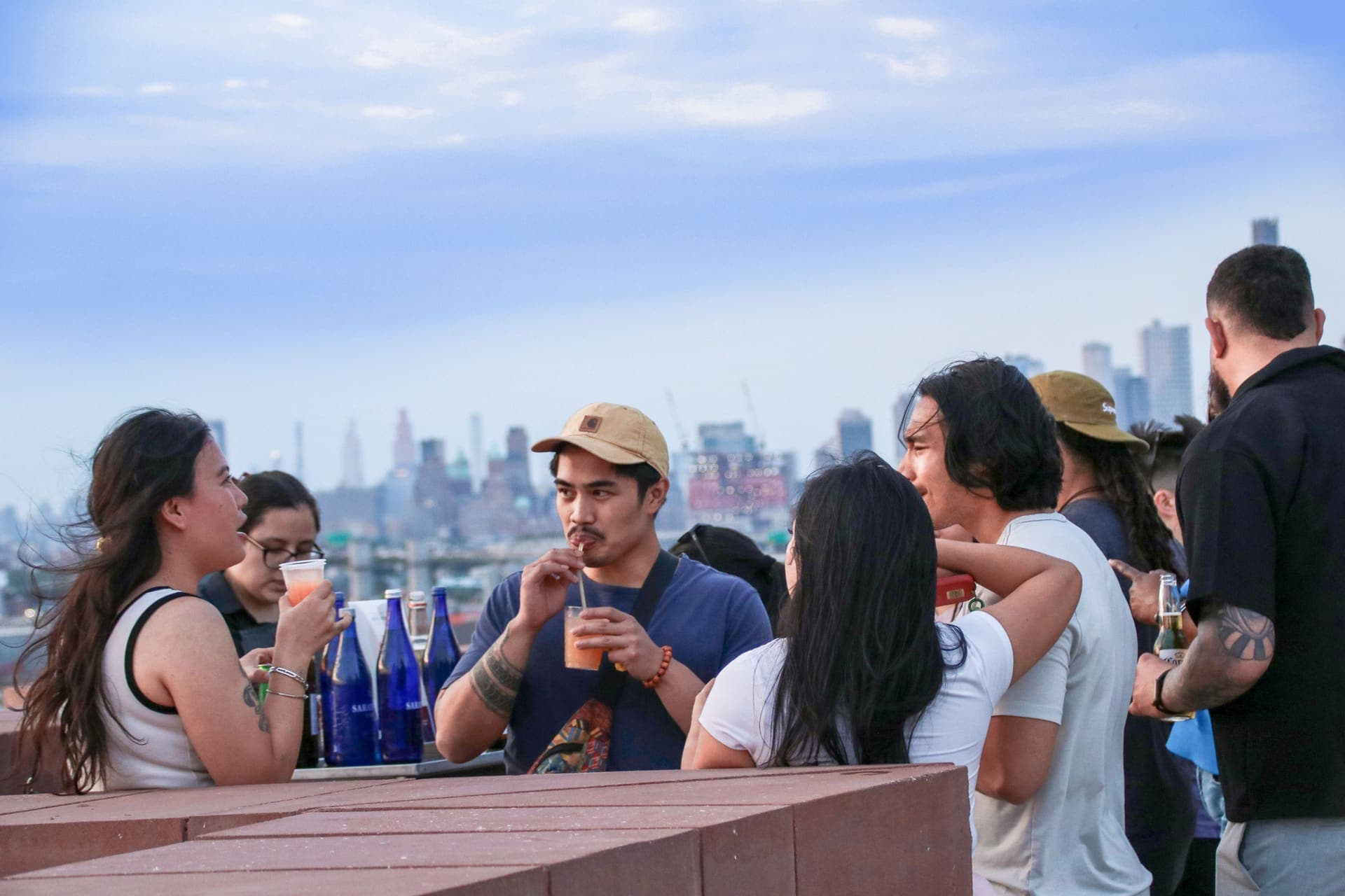 Guests gathered along the terrace railing with the skyline beyond at 875 Fourth Avenue