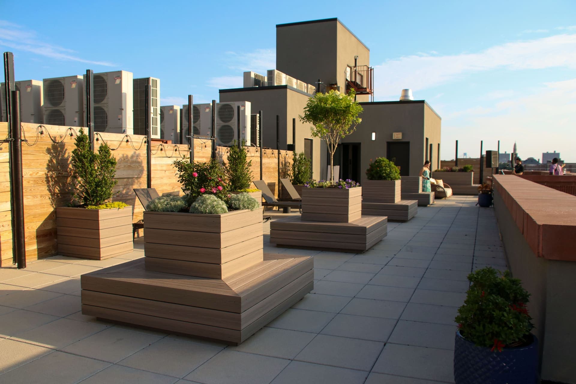 The rooftop lounge with planters and bench seating overlooking Brooklyn at 875 Fourth Avenue