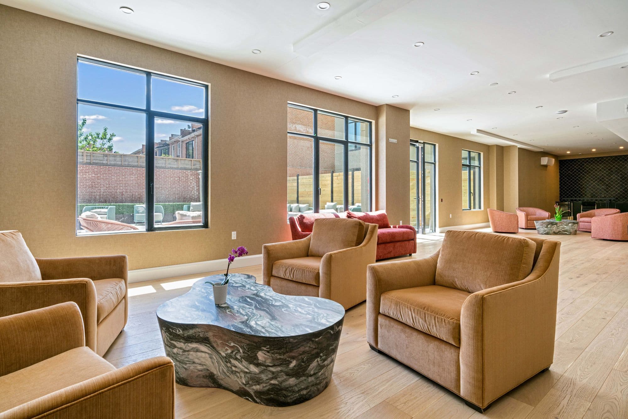 The resident co-working lounge at 875 Fourth Avenue, furnished with armchairs and a stone table, with no people in frame