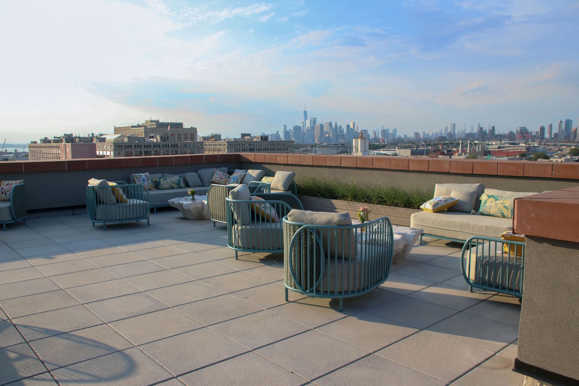 Rooftop lounge seating framed by the full New York City skyline at 875 Fourth Avenue
