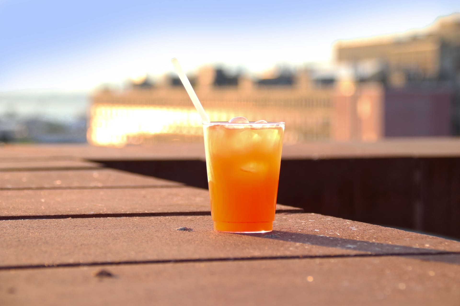 A cocktail resting on the terrace railing at sunset with Brooklyn below at 875 Fourth Avenue